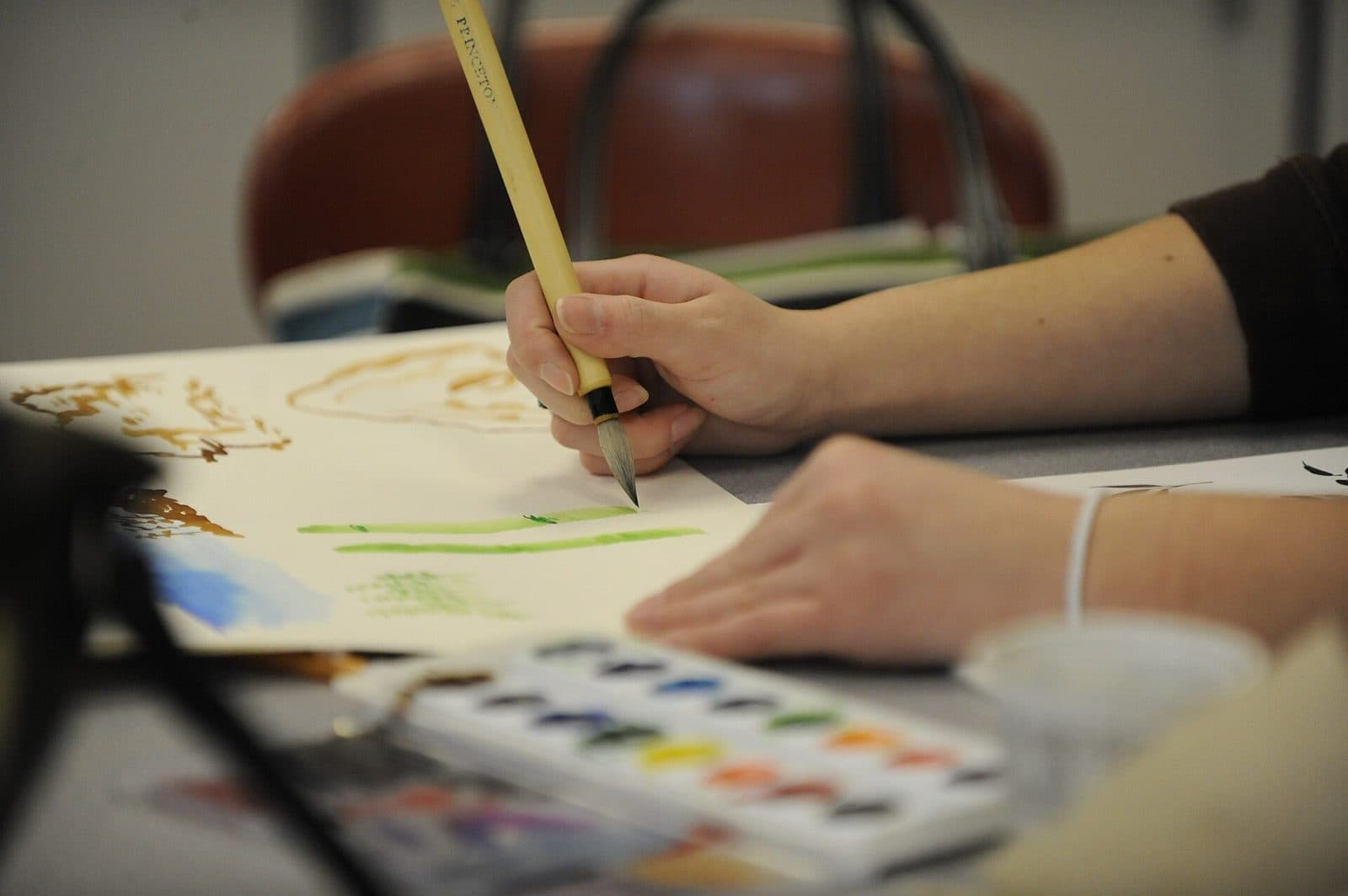 A student painting with watercolors in an art class