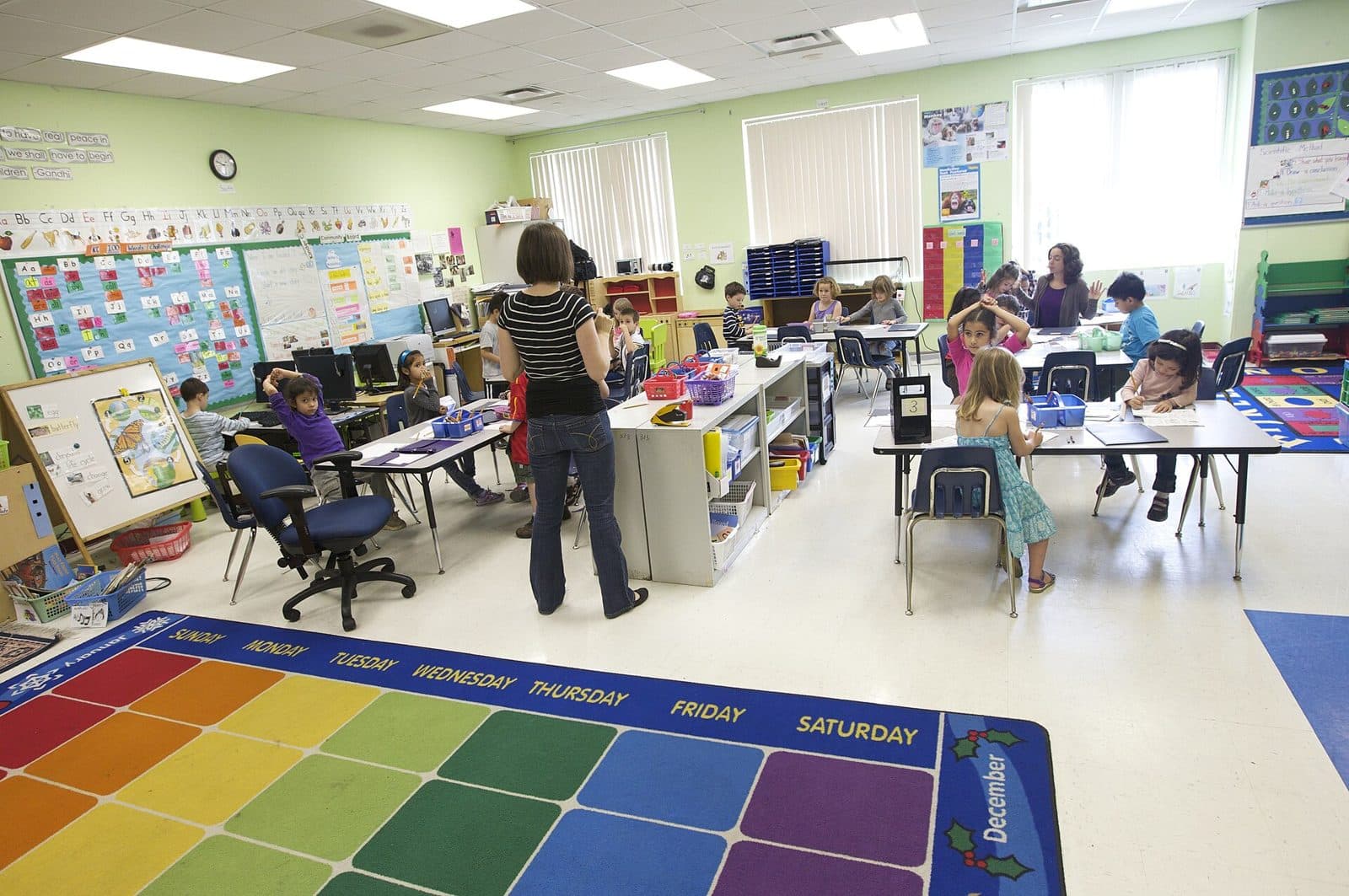 A bright elementary classroom with students working at tables