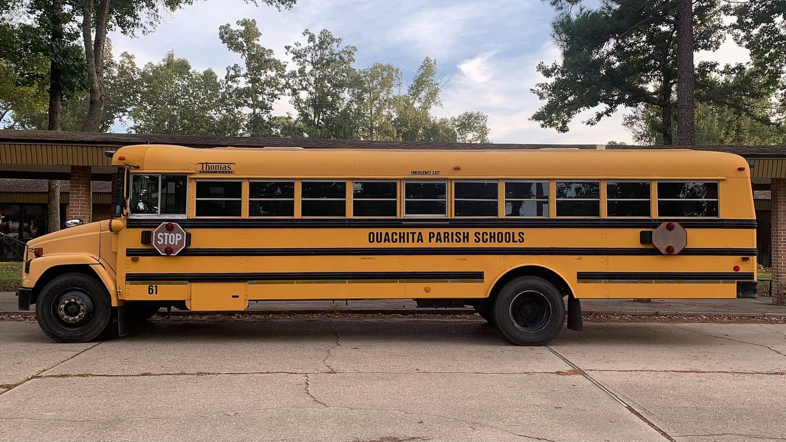 A yellow school bus parked outside an elementary school