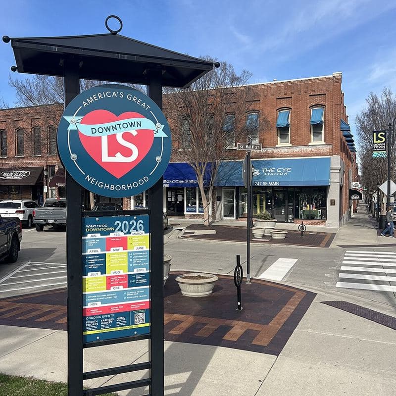 Informational kiosk for downtown Lee's Summit on the corner of Main Street and Third Street, with storefronts of local businesses in the bac